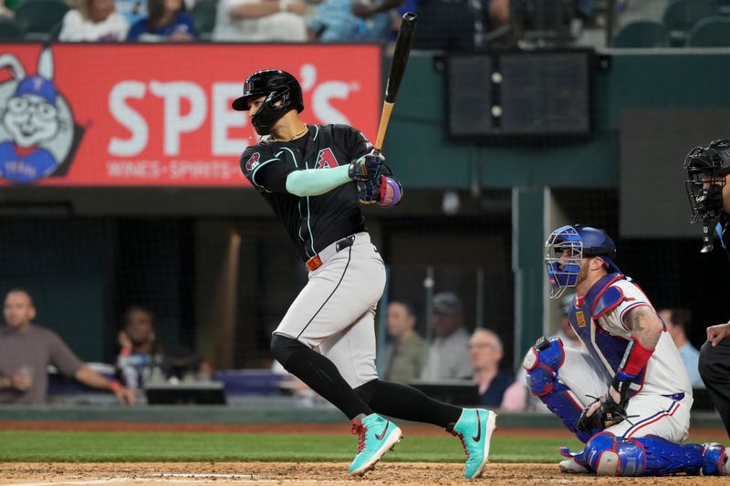 May 29, 2024; Arlington, Texas, USA;  Arizona Diamondbacks left fielder Lourdes Gurriel Jr. (12) follows through on his single against the Texas Rangers during the eighth inning at Globe Life Field. Mandatory Credit: Jim Cowsert-USA TODAY Sports