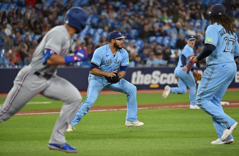 Sep 14, 2023; Toronto, Ontario, CAN;  Toronto Blue Jays relief pitcher Yimi Garcia (93) fields a soft grounder hit by Texas Rangers designated hitter Leody Taveras (3) but cannot make an out in the eighth inning at Rogers Centre. Mandatory Credit: Dan Hamilton-USA TODAY Sports