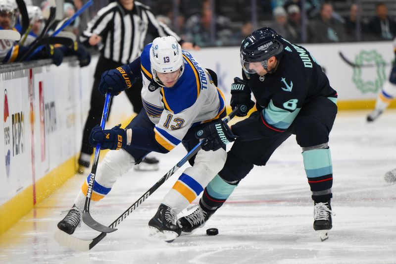 Jan 26, 2024; Seattle, Washington, USA; St. Louis Blues right wing Alexey Toropchenko (13) and Seattle Kraken defenseman Brian Dumoulin (8) play the puck during the third period at Climate Pledge Arena. Mandatory Credit: Steven Bisig-USA TODAY Sports