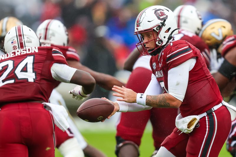 Nov 11, 2023; Columbia, South Carolina, USA; South Carolina Gamecocks quarterback Spencer Rattler (7) hands off to running back Mario Anderson (24) against the Vanderbilt Commodores in the second quarter at Williams-Brice Stadium. Mandatory Credit: Jeff Blake-USA TODAY Sports