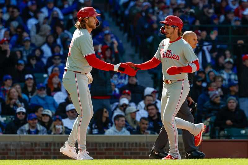 Apr 26, 2025; Chicago, Illinois, USA; Philadelphia Phillies third baseman Alec Bohm (28) and second baseman Bryson Stott (5) celebrate after they both scored against the Chicago Cubs during the fourth inning at Wrigley Field. Mandatory Credit: Kamil Krzaczynski-Imagn Images