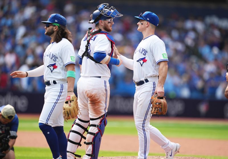 Jul 16, 2023; Toronto, Ontario, CAN; Toronto Blue Jays catcher Danny Jansen (9) and third baseman Matt Chapman (26) celebrate the win at the end of the ninth inning against the Arizona Diamondbacks at Rogers Centre. Mandatory Credit: Nick Turchiaro-USA TODAY Sports