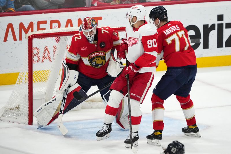 Jan 17, 2024; Sunrise, Florida, USA; Florida Panthers goaltender Sergei Bobrovsky (72) makes a save behind defenseman Niko Mikkola (77) and Detroit Red Wings center Joe Veleno (90) during the second period at Amerant Bank Arena. Mandatory Credit: Jasen Vinlove-USA TODAY Sports