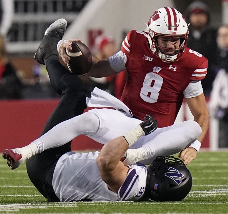 Nov 11, 2023; Madison, Wisconsin, USA; Wisconsin quarterback Tanner Mordecai (8) is sacked by Northwestern defensive lineman Aidan Hubbard (91) during the third quarter at Camp Randall Stadium. Mandatory Credit: Mark Hoffman-USA TODAY Sports