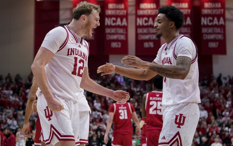 Feb 7, 2026; Bloomington, Indiana, USA; Indiana Hoosiers forward Tucker DeVries (12) celebrates with Indiana Hoosiers guard Jasai Miles (0) during the second half at Simon Skjodt Assembly Hall. Mandatory Credit: Robert Goddin-Imagn Images