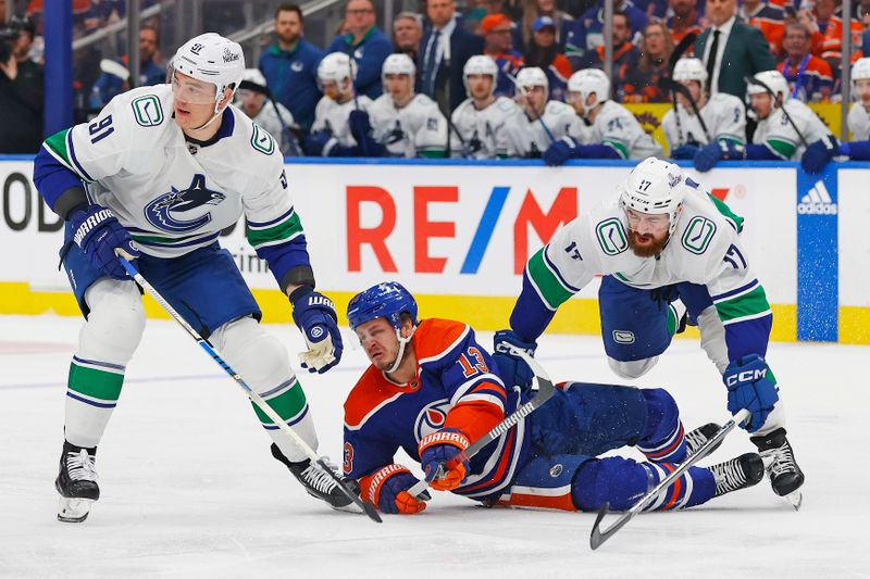 May 12, 2024; Edmonton, Alberta, CAN;Vancouver Canucks defensemen Filip Hornek (17) trips up Edmonton Oilers forward Mattias Janmark (13) during the first period in game three of the second round of the 2024 Stanley Cup Playoffs at Rogers Place. Mandatory Credit: Perry Nelson-USA TODAY Sports