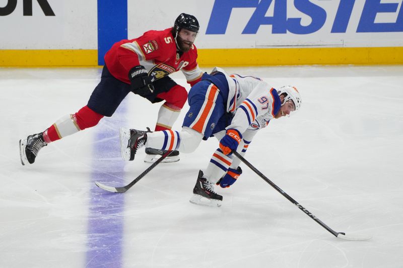 Jun 9, 2025; Sunrise, Florida, USA; Edmonton Oilers center Connor McDavid (97) battles for the puck against Florida Panthers defenseman Aaron Ekblad (5) during the first period in game three of the 2025 Stanley Cup Final at Amerant Bank Arena. Mandatory Credit: Jim Rassol-Imagn Images