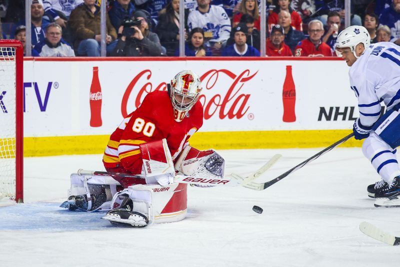 Jan 18, 2024; Calgary, Alberta, CAN; Calgary Flames goaltender Dan Vladar (80) makes a save against Toronto Maple Leafs center Max Domi (11) during the third period at Scotiabank Saddledome. Mandatory Credit: Sergei Belski-USA TODAY Sports