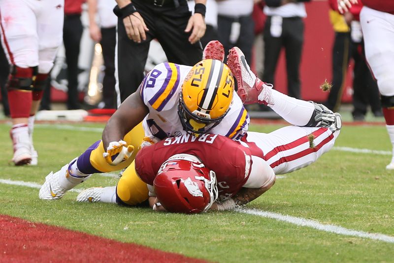 Nov 21, 2020; Fayetteville, Arkansas, USA;  Arkansas Razorbacks quarterback Feleipe Franks (13) dives for a touchdown as LSU Tigers defensive lineman Jaquelin Roy (99) defends during the second quarter at Donald W. Reynolds Razorback Stadium. Mandatory Credit: Nelson Chenault-USA TODAY Sports