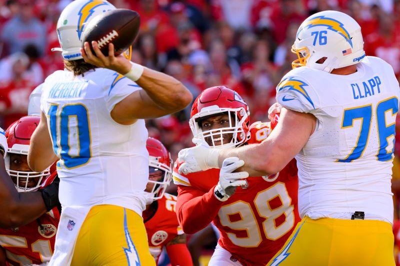 Kansas City Chiefs defensive tackle Tershawn Wharton (98) tries to get past Los Angeles Chargers center Will Clapp (76) to pressure Los Angeles Chargers quarterback Justin Herbert (10) during the first half of an NFL football game, Sunday, Oct. 22, 2023 in Kansas City, Mo. (AP Photo/Reed Hoffmann)