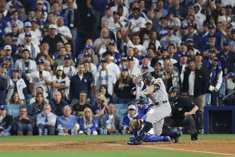 Oct 25, 2024; Los Angeles, California, USA; New York Yankees designated hitter Giancarlo Stanton (27) hits a two-run home run in the sixth inning against the Los Angeles Dodgers during game one of the 2024 MLB World Series at Dodger Stadium. Mandatory Credit:  Jason Parkhurst-Imagn Images