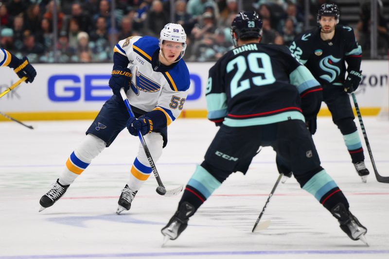 Jan 26, 2024; Seattle, Washington, USA; St. Louis Blues center Nikita Alexandrov (59) plays the puck while defended by Seattle Kraken defenseman Vince Dunn (29) during the third period at Climate Pledge Arena. Mandatory Credit: Steven Bisig-USA TODAY Sports