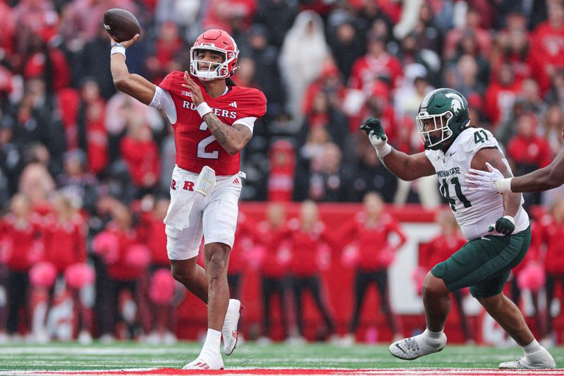 Oct 14, 2023; Piscataway, New Jersey, USA; Rutgers Scarlet Knights quarterback Gavin Wimsatt (2) throws the ball as Michigan State Spartans defensive lineman Derrick Harmon (41) pursues during the first half at SHI Stadium. Mandatory Credit: Vincent Carchietta-USA TODAY Sports