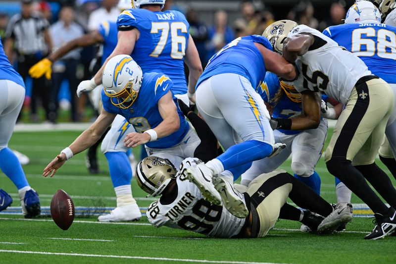 Los Angeles Chargers quarterback Easton Stick (2) fumbles in the first half of an NFL football game against the New Orleans Saints in Inglewood, Calif., Sunday, Aug. 20, 2023. (AP Photo/Alex Gallardo)