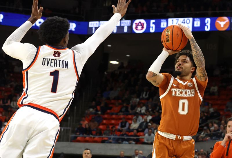 Jan 28, 2026; Auburn, Alabama, USA;  TTexas Longhorns guard Jordan Pope (0) takes a shot as Auburn Tigers guard Kevin Overton (1) closes in during the first half at Neville Arena. Mandatory Credit: John Reed-Imagn Images