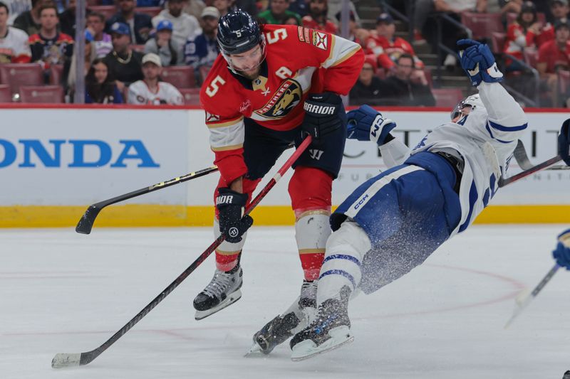 Nov 27, 2024; Sunrise, Florida, USA; Florida Panthers defenseman Aaron Ekblad (5) and Toronto Maple Leafs center John Tavares (91) collide during the second period at Amerant Bank Arena. Mandatory Credit: Sam Navarro-Imagn Images