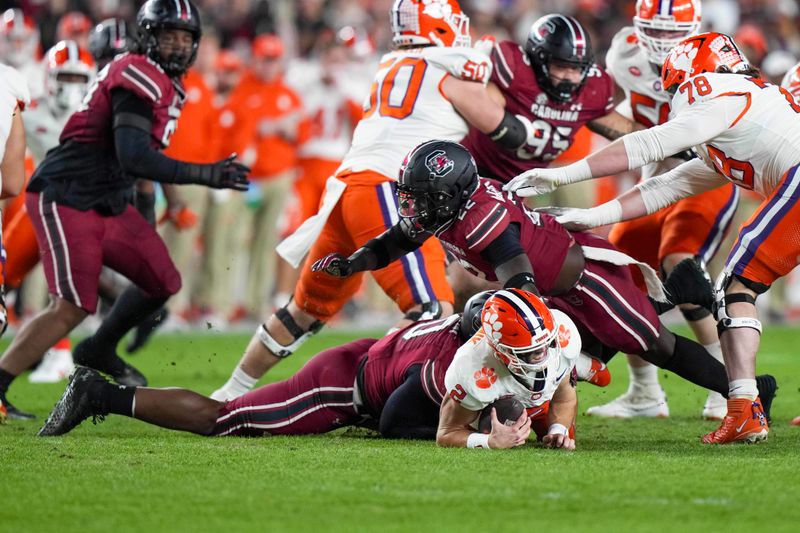 Nov 25, 2023; Columbia, South Carolina, USA; Clemson Tigers quarterback Cade Klubnik (2) is sacked by South Carolina Gamecocks defensive end Tyreek Johnson (10) in the first half at Williams-Brice Stadium. Mandatory Credit: David Yeazell-USA TODAY Sports