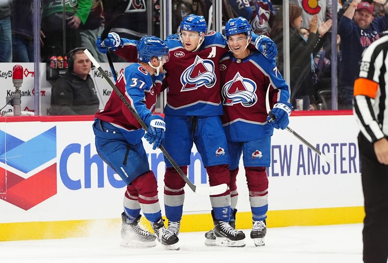 Oct 18, 2024; Denver, Colorado, USA; Colorado Avalanche center Nathan MacKinnon (29) and center Casey Mittelstadt (37) and center Ross Colton (20) celebrate defeating the Anaheim Ducks in overtime at Ball Arena. Mandatory Credit: Ron Chenoy-Imagn Images