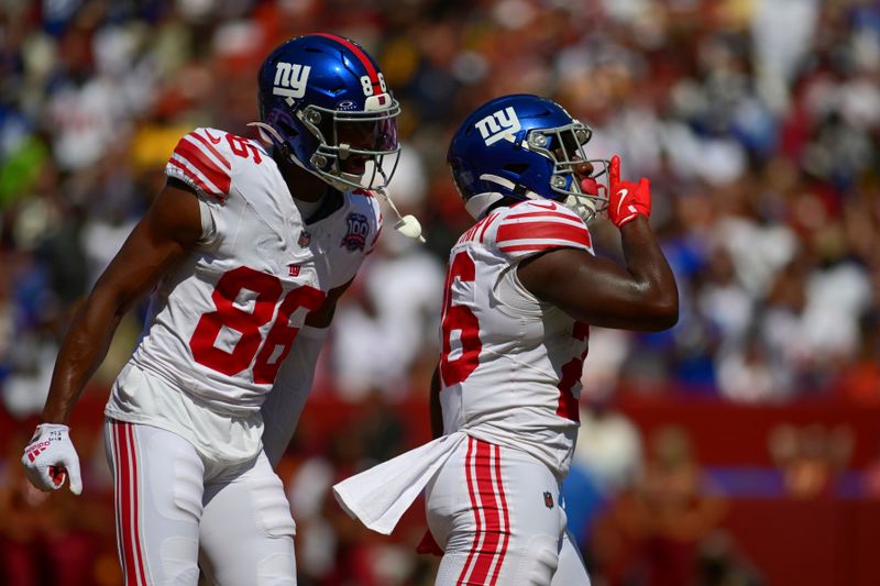 New York Giants running back Devin Singletary (26) and Darius Slayton (86) celebrate Singletary's touchdown run against the Washington Commanders during the first half of an NFL football game in Landover, Md., Sunday, Sept. 15, 2024. (AP Photo/Steve Ruark)