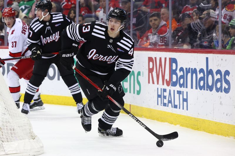 Mar 9, 2024; Newark, New Jersey, USA; New Jersey Devils defenseman Luke Hughes (43) skates with the puck against the Carolina Hurricanes during the first period at Prudential Center. Mandatory Credit: Ed Mulholland-USA TODAY Sports