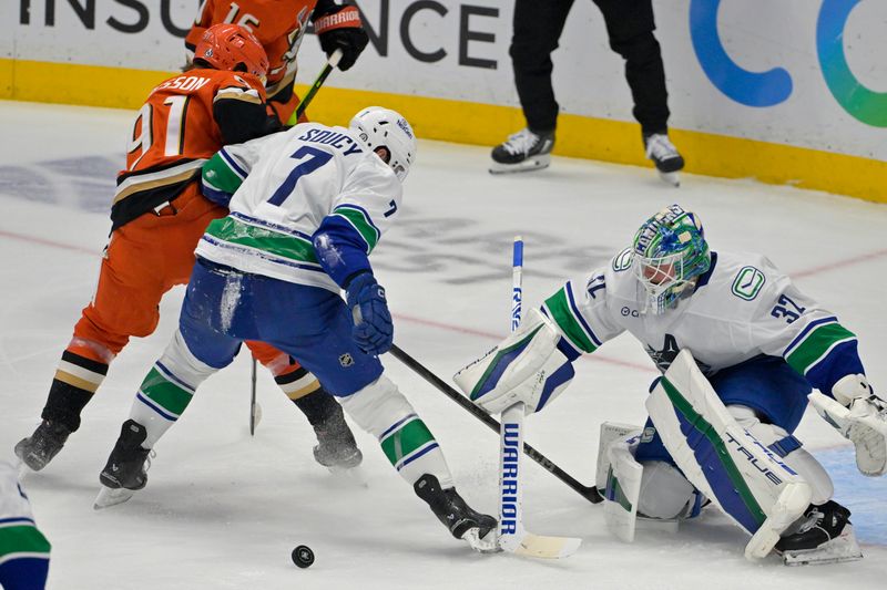 Nov 5, 2024; Anaheim, California, USA;Vancouver Canucks defenseman Carson Soucy (7) battle with Anaheim Ducks center Leo Carlsson (91) as Vancouver Canucks goaltender Kevin Lankinen (32) pokes the puck away from the goal in the first period at Honda Center. Mandatory Credit: Jayne Kamin-Oncea-Imagn Images