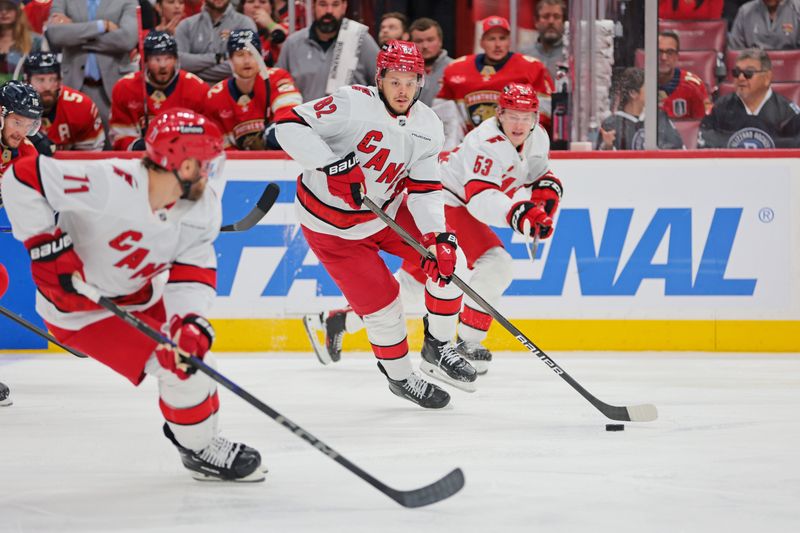 May 26, 2025; Sunrise, Florida, USA; Carolina Hurricanes center Jordan Staal (11), Carolina Hurricanes center Jesperi Kotkaniemi (82) and Carolina Hurricanes right wing Jackson Blake (53) control the puck during the first period against the Florida Panthers in game four of the Eastern Conference Final of the 2025 Stanley Cup Playoffs at Amerant Bank Arena. Mandatory Credit: Sam Navarro-Imagn Images