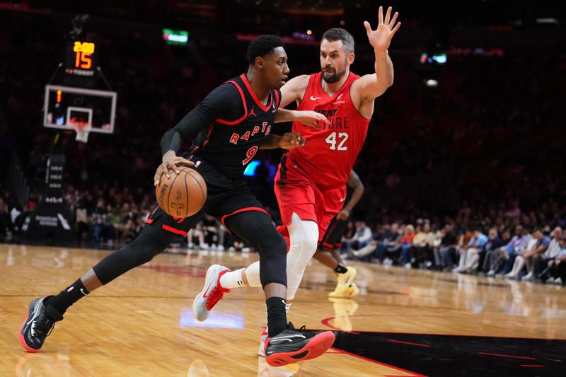 MIAMI, FLORIDA - DECEMBER 12: RJ Barrett #9 of the Toronto Raptors dribbles the ball against Kevin Love #42 of the Miami Heat during the third quarter at Kaseya Center on December 12, 2024 in Miami, Florida. NOTE TO USER: User expressly acknowledges and agrees that, by downloading and or using this Photograph, user is consenting to the terms and conditions of the Getty Images License Agreement. (Photo by Rich Storry/Getty Images)