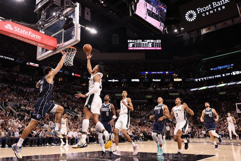 SAN ANTONIO, TEXAS - OCTOBER 25: Tre Jones #33 of the San Antonio Spurs lays up a shot over Josh Green #8 of the Dallas Mavericks during the fourth quarter of the NBA game at Frost Bank Center on October 25, 2023 in San Antonio, Texas.  The Mavericks defeated the Spurs 126-119. NOTE TO USER: User expressly acknowledges and agrees that, by downloading and or using this photograph, User is consenting to the terms and conditions of the Getty Images License Agreement.  (Photo by Christian Petersen/Getty Images)