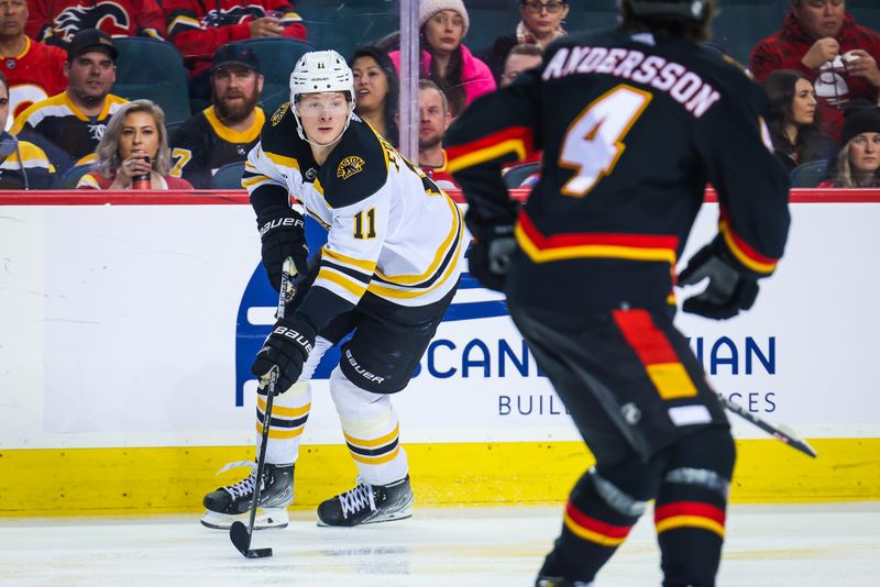 Feb 28, 2023; Calgary, Alberta, CAN; Boston Bruins center Trent Frederic (11) controls the puck against the Calgary Flames during the third period at Scotiabank Saddledome. Mandatory Credit: Sergei Belski-USA TODAY Sports