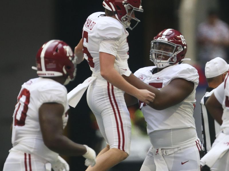 Sep 4, 2021; Atlanta, Georgia, USA;  Alabama offensive lineman JC Latham (65) lifts Alabama kicker Will Reichard (16) after Reichard connected for his second field goal of the first half against Miami at Mercedes-Benz Stadium. Mandatory Credit: Gary Cosby-USA TODAY Sports