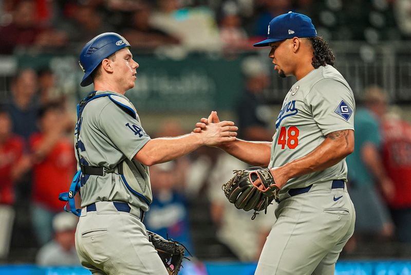 Sep 15, 2024; Cumberland, Georgia, USA; Los Angeles Dodgers catcher Austin Barnes (15) and relief pitcher Brusdar Graterol (48) react after the Dodgers defeated the Atlanta Braves at Truist Park. Mandatory Credit: Dale Zanine-Imagn Images