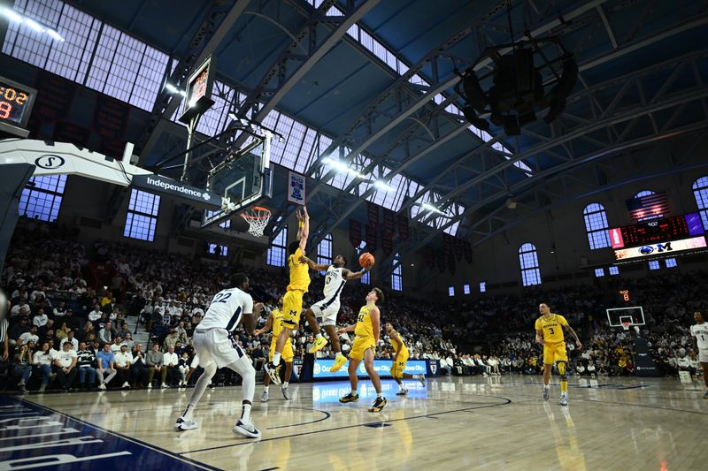 Jan 7, 2024; Philadelphia, Pennsylvania, USA; Penn State Nittany Lions guard Kanye Clary (0) shoots against Michigan Wolverines forward Olivier Nkamhoua (13) in the first half at The Palestra. Mandatory Credit: Kyle Ross-USA TODAY Sports