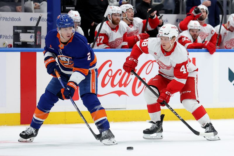 Oct 22, 2024; Elmont, New York, USA; New York Islanders defenseman Mike Reilly (2) plays the puck against Detroit Red Wings right wing Jonatan Berggren (48) during the first period at UBS Arena. Mandatory Credit: Brad Penner-Imagn Images