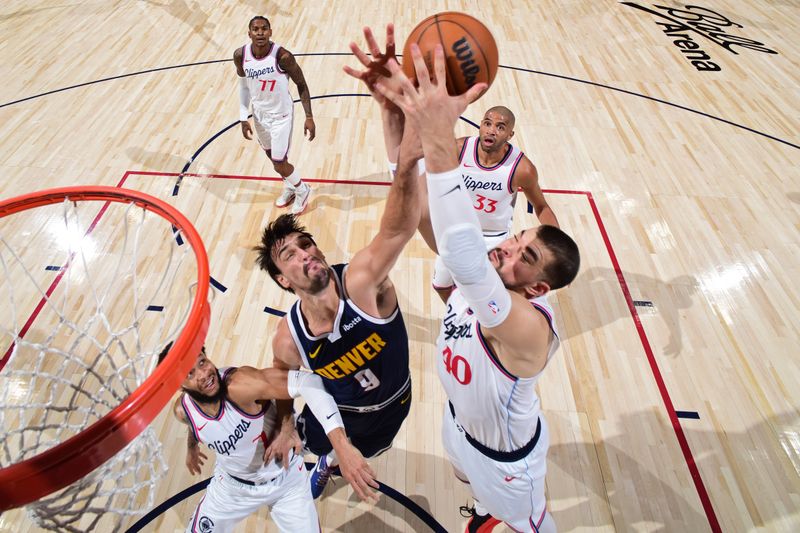 DENVER, CO - OCTOBER 26: Dario Saric #9 of the Denver Nuggets and Ivica Zubac #40 of the LA Clippers battle for a rebound during the game on October 26, 2024 at the Ball Arena in Denver, Colorado. NOTE TO USER: User expressly acknowledges and agrees that, by downloading and/or using this Photograph, user is consenting to the terms and conditions of the Getty Images License Agreement. Mandatory Copyright Notice: Copyright 2024 NBAE (Photo by Garrett Ellwood/NBAE via Getty Images)