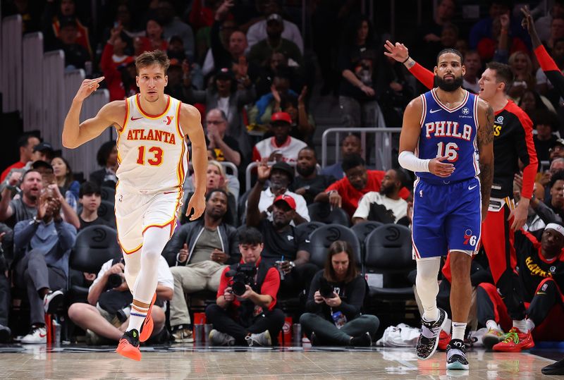 ATLANTA, GEORGIA - OCTOBER 14:  Bogdan Bogdanovic #13 of the Atlanta Hawks reacts after a three-point basket against Caleb Martin #16 of the Philadelphia 76ers during the second quarter at State Farm Arena on October 14, 2024 in Atlanta, Georgia.  NOTE TO USER: User expressly acknowledges and agrees that, by downloading and/or using this photograph, user is consenting to the terms and conditions of the Getty Images License Agreement.  (Photo by Kevin C. Cox/Getty Images)