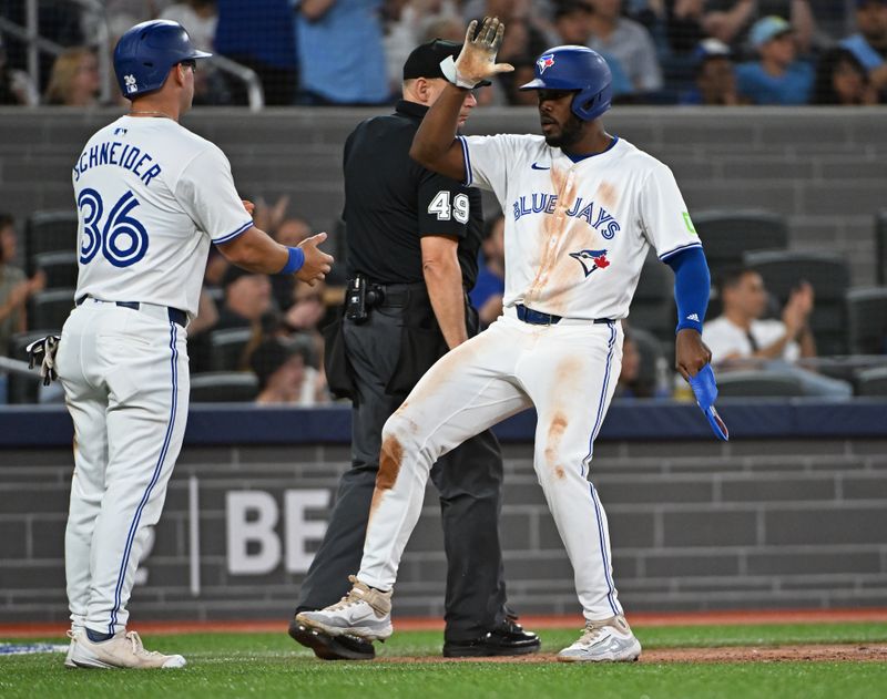 Aug 11, 2024; Toronto, Ontario, CAN; Toronto Blue Jays third base Luis De Los Santos (20) and left field Davis Schneider (36) celebrate scoring in the eighth inning against the Oakland Athletics at Rogers Centre. Mandatory Credit: Gerry Angus-USA TODAY Sports