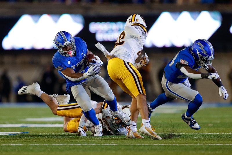 Oct 14, 2023; Colorado Springs, Colorado, USA; Air Force Falcons fullback Emmanuel Michel (4) runs the ball against Wyoming Cowboys safety Isaac White (42) and linebacker Easton Gibbs (28) in the fourth quarter at Falcon Stadium. Mandatory Credit: Isaiah J. Downing-USA TODAY Sports