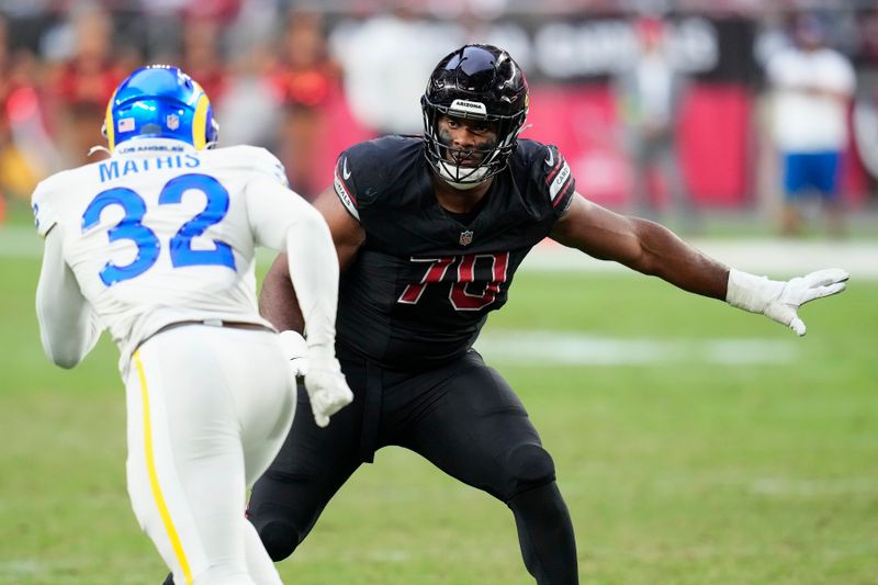Arizona Cardinals offensive tackle Paris Johnson Jr., right, moves over to block Los Angeles Rams linebacker Ochaun Mathis (32) during the second half of an NFL football game Sunday, Nov. 26, 2023, in Glendale, Ariz. The Rams won 37-14. (AP Photo/Ross D. Franklin)