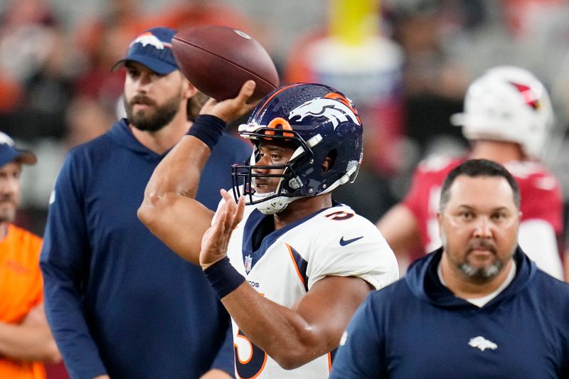 Denver Broncos quarterback Russell Wilson warms up prior to an NFL preseason football game against the Arizona Cardinals, Friday, Aug. 11, 2023, in Glendale, Ariz. (AP Photo/Ross D. Franklin)