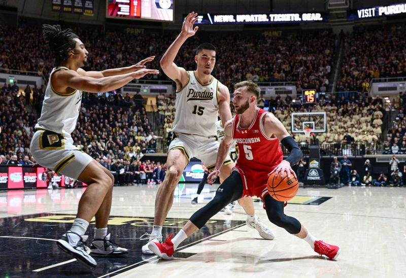 Mar 10, 2024; West Lafayette, Indiana, USA; Wisconsin Badgers forward Tyler Wahl (5) controls the ball as Purdue Boilermakers center Zach Edey (15) and forward Trey Kaufman-Renn (4) defend during the first half at Mackey Arena. Mandatory Credit: Marc Lebryk-USA TODAY Sports