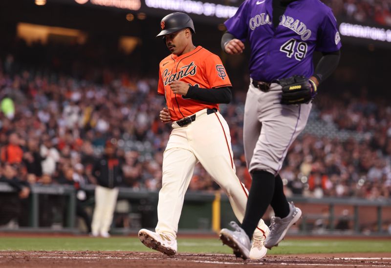 May 2, 2025; San Francisco, California, USA; San Francisco Giants first baseman LaMonte Wade Jr. (31) scores a run on a wild pitch by Colorado Rockies starting pitcher Antonio Senzatela (49) during the second inning at Oracle Park. Mandatory Credit: Kelley L Cox-Imagn Images
