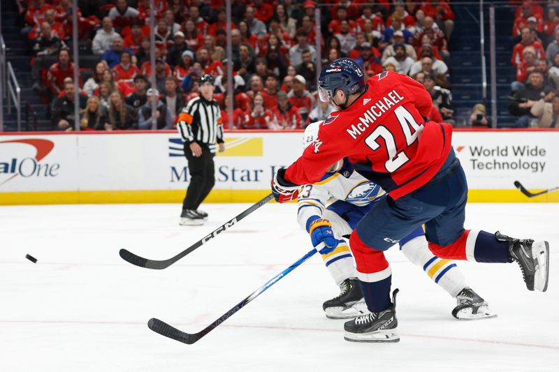 Nov 22, 2023; Washington, District of Columbia, USA; Washington Capitals center Connor McMichael (24) shoots the puck as Buffalo Sabres defenseman Mattias Samuelsson (23) defends in the first period at Capital One Arena. Mandatory Credit: Geoff Burke-USA TODAY Sports