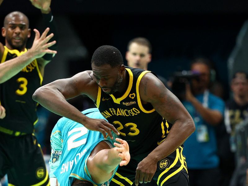 CHARLOTTE, NORTH CAROLINA - MARCH 29: Draymond Green #23 of the Golden State Warriors is called for an offensive foul against Grant Williams #2 of the Charlotte Hornets during the second half of the game at Spectrum Center on March 29, 2024 in Charlotte, North Carolina. NOTE TO USER: User expressly acknowledges and agrees that, by downloading and or using this photograph, User is consenting to the terms and conditions of the Getty Images License Agreement. (Photo by Jared C. Tilton/Getty Images)