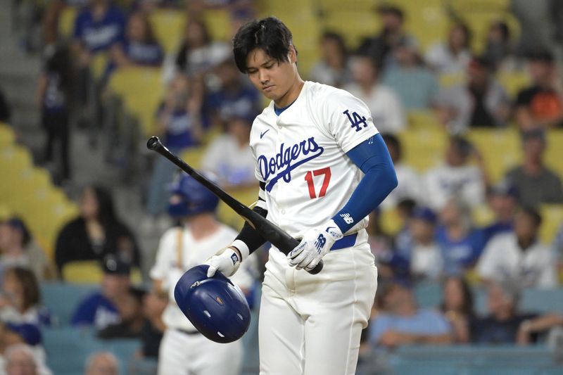 Jul 24, 2024; Los Angeles, California, USA;   Los Angeles Dodgers designated hitter Shohei Ohtani (17) checks hit bat after a foul ball in the eighth inning against the San Francisco Giants Dodger Stadium. Mandatory Credit: Jayne Kamin-Oncea-USA TODAY Sports