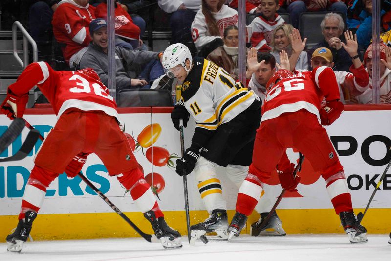 Nov 23, 2024; Detroit, Michigan, USA; Boston Bruins center Trent Frederic (11) and Detroit Red Wings right wing Christian Fischer (36) fight for control of the puck during the third period at Little Caesars Arena. Mandatory Credit: Brian Bradshaw Sevald-Imagn Images