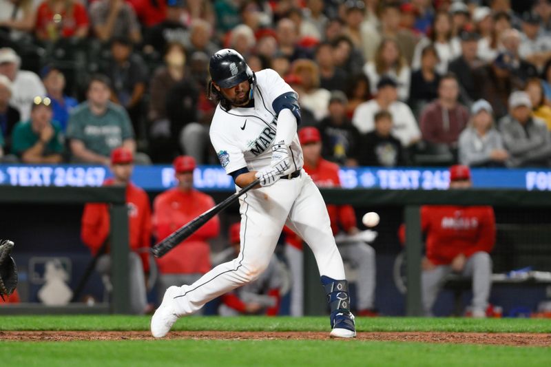 Sep 11, 2023; Seattle, Washington, USA; Seattle Mariners third baseman Eugenio Suarez (28) hits a single against the Los Angeles Angels during the ninth inning at T-Mobile Park. Mandatory Credit: Steven Bisig-USA TODAY Sports