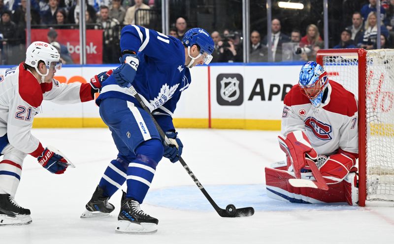 Apr 12, 2025; Toronto, Ontario, CAN;  Toronto Maple Leafs forward John Tavares (91) moves in on Montreal Canadiens goalie Jakub Dobes (75) in the first period at Scotiabank Arena. Mandatory Credit: Dan Hamilton-Imagn Images