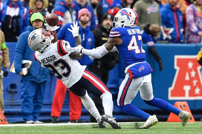 New England Patriots wide receiver Jalen Reagor (83) makes an over the shoulder catch with Buffalo Bills cornerback Christian Benford defending during the second half of an NFL football game in Orchard Park, N.Y., Sunday, Dec. 31, 2023. (AP Photo/Adrian Kraus)