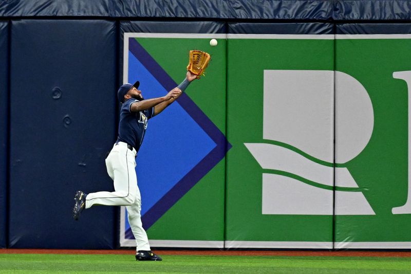 Apr 23, 2024; St. Petersburg, Florida, USA; Tampa Bay Rays right fielder Amen Rosario (10) attempts to catch a fly ball in the sixth inning against the Detroit Tigers at Tropicana Field. Mandatory Credit: Jonathan Dyer-USA TODAY Sports