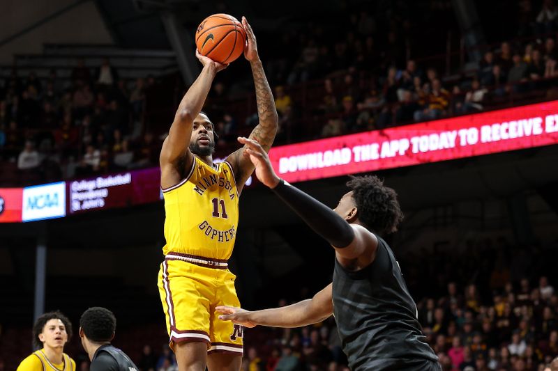 Feb 1, 2025; Minneapolis, Minnesota, USA; Minnesota Golden Gophers guard Femi Odukale (11) shoots as Washington Huskies forward Great Osobor (1) defends during the first half at Williams Arena. Mandatory Credit: Matt Krohn-Imagn Images